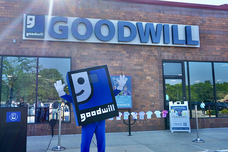Goodwill mascot in front of a Goodwill store